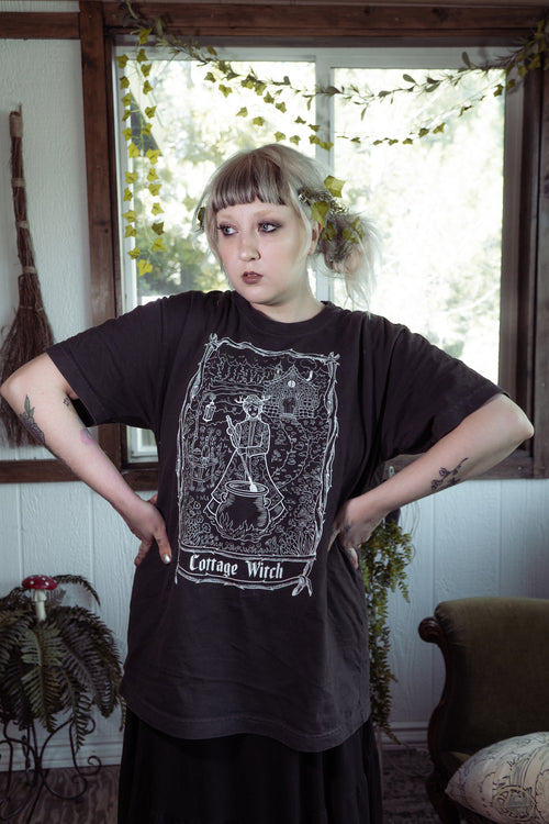 Cottage Witch graphic tee worn by model, relaxed-fit black cotton t-shirt